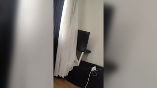 Sexy beautiful woman wearing completely nude curtains in her home.